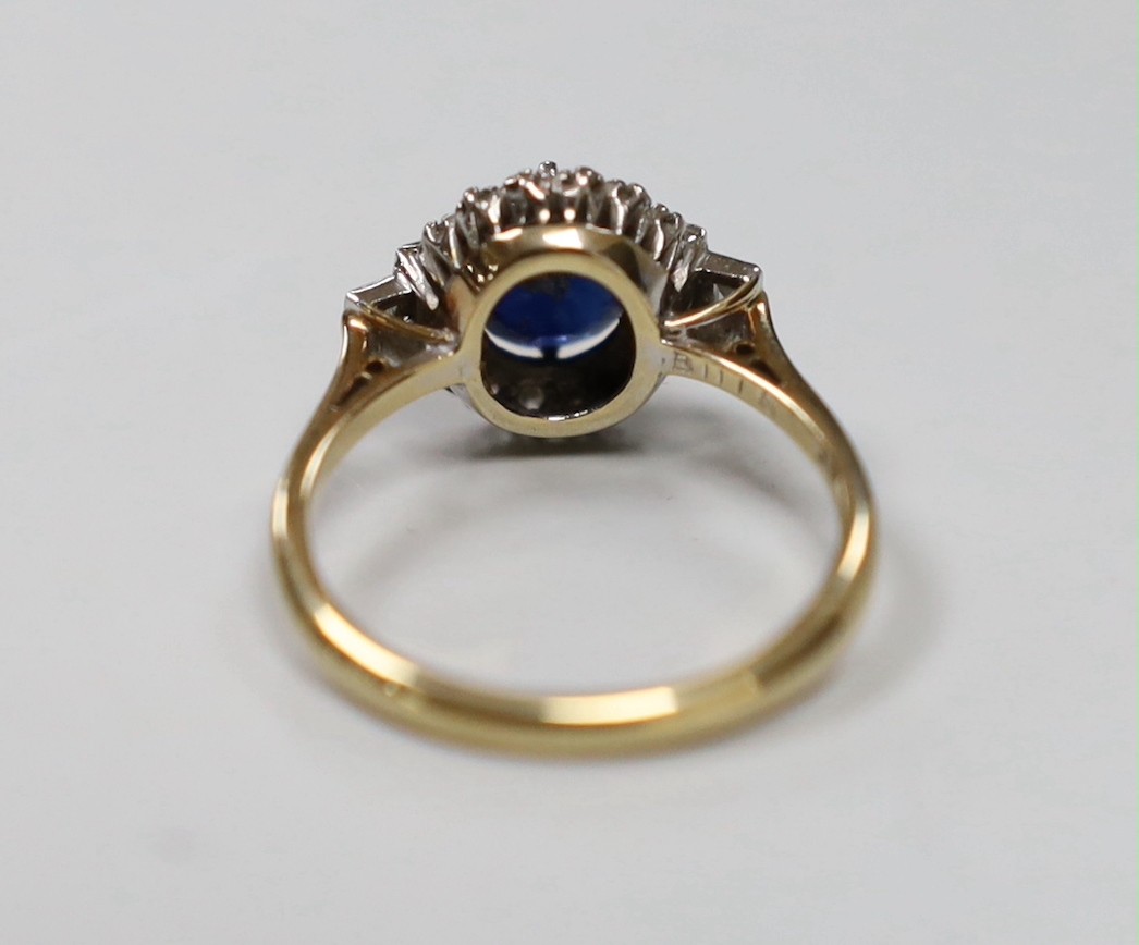 An Art Deco 18ct and plat, sapphire and diamond set oval dress ring with baguette cut diamond set shoulders, size P, gross weight 4.5 grams, in Art Deco celluloid box.